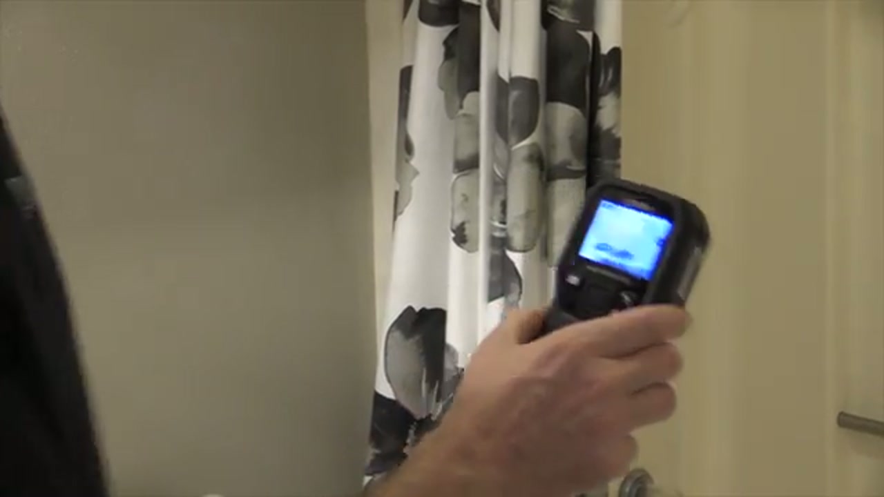 Technician holding a thermal imaging camera during a leak inspection