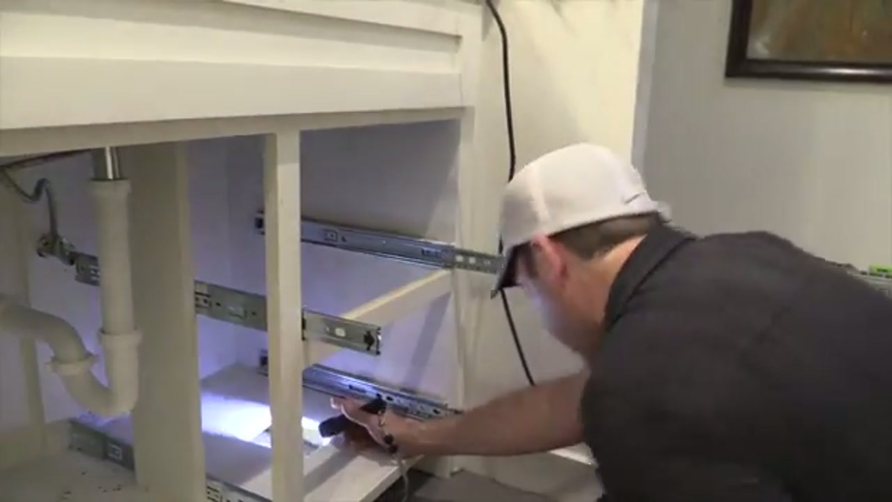 Technician inspecting bathroom plumbing connections during leak detection in Trophy Club, Texas