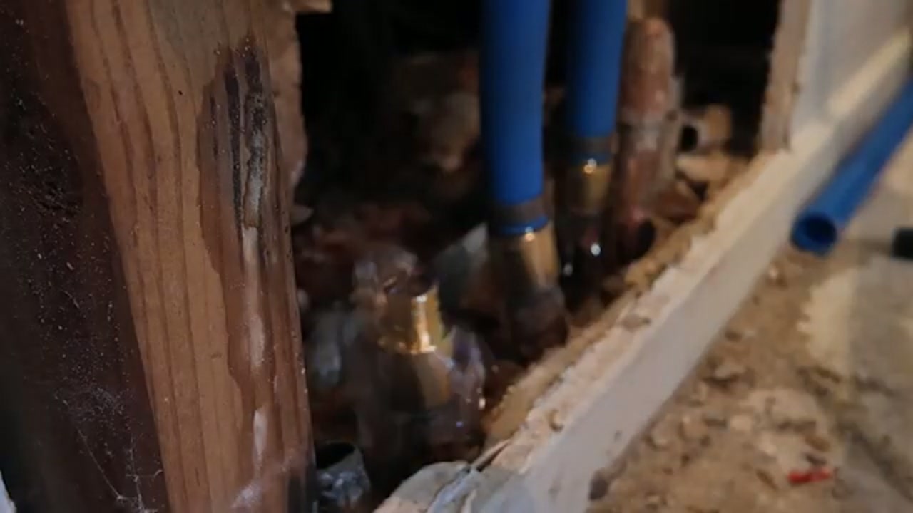 Pool plumbing pipes near a wall during inspection